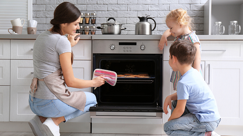 mamma con bambini che guarda un forno